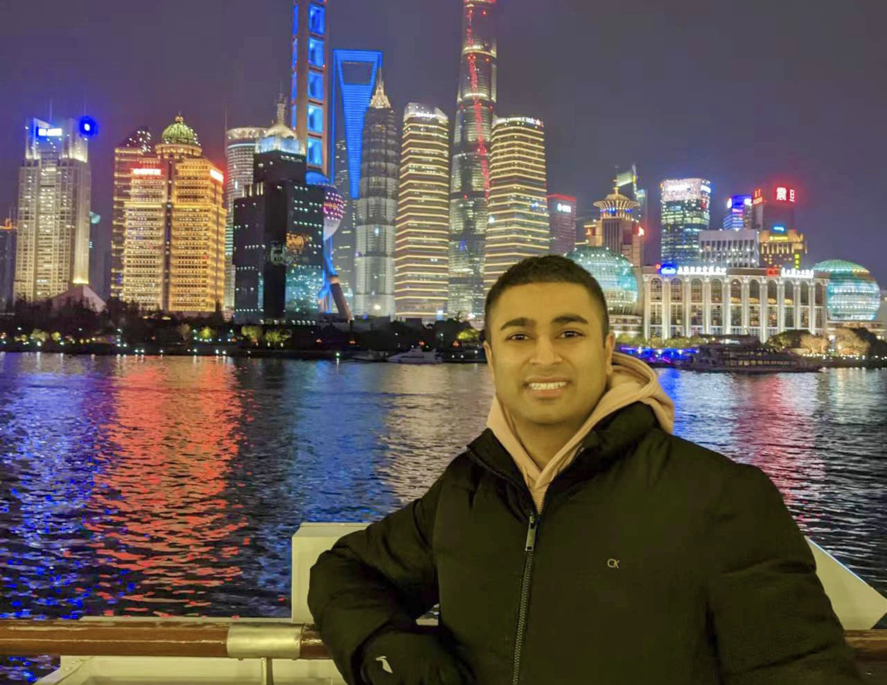 A male student stands near a waterfront in Shanghai, China